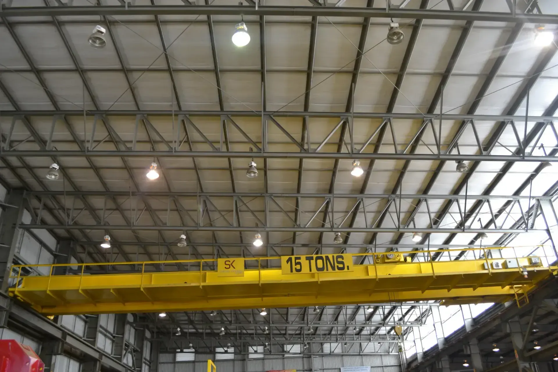 Grúa viajera bipuente amarilla Strong Kranes de 15 toneladas dentro de una nave industrial